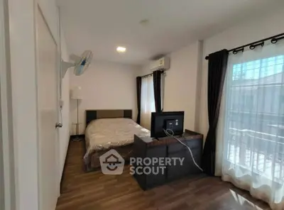 Spacious bedroom with modern decor and natural light, featuring a comfortable bed and stylish furnishings.