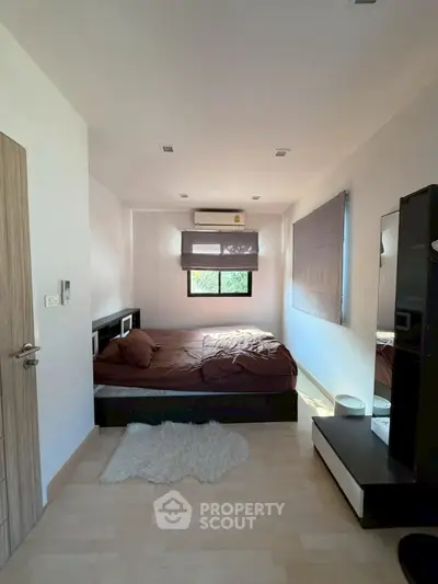 Cozy bedroom with modern decor and natural light, featuring a comfortable bed and stylish furnishings.