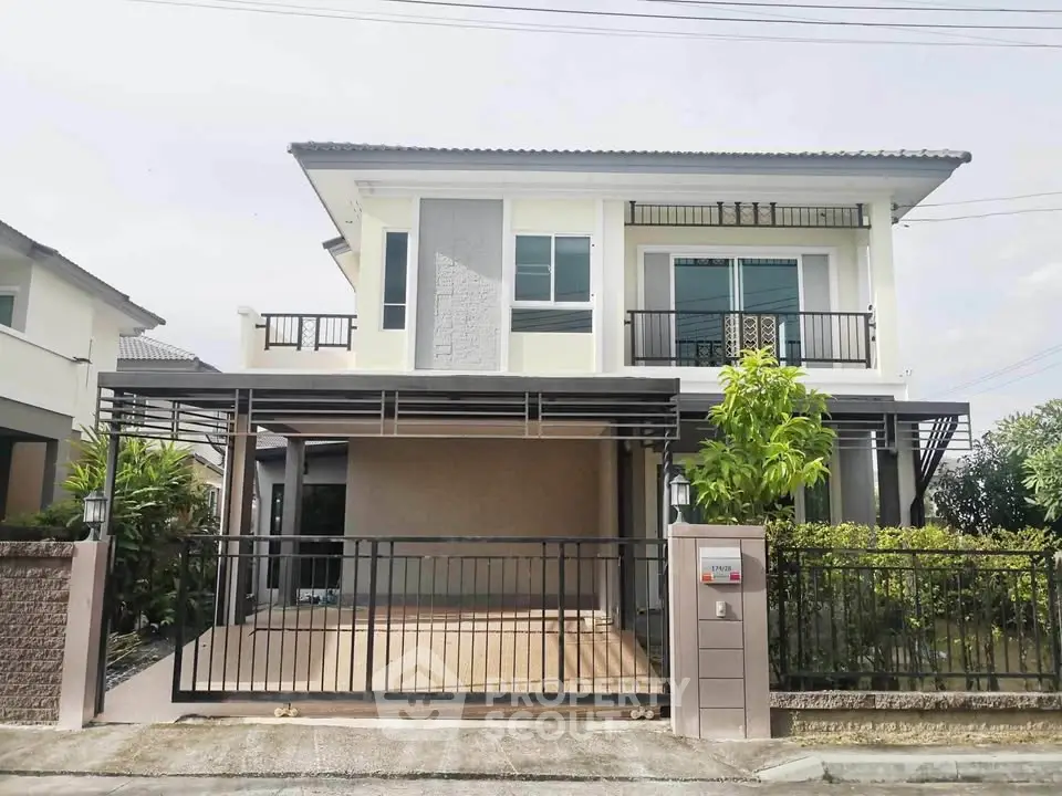 Modern two-story house with spacious driveway and balcony, ideal for family living.