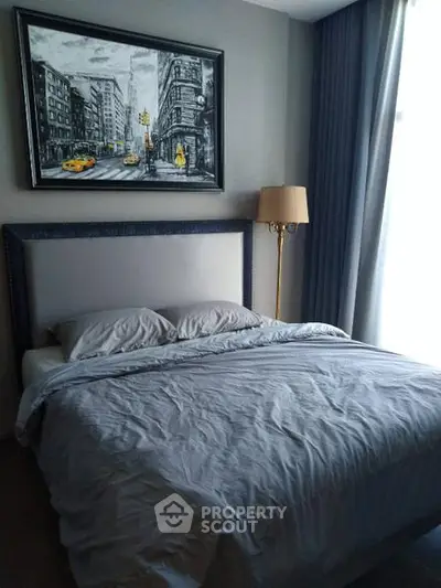 Cozy bedroom with stylish decor and large window for natural light.