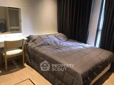 Cozy bedroom with a large bed, elegant dark curtains, and a study area, perfect for relaxation and productivity.