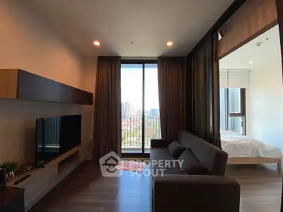 Modern living room with large window and city view, featuring sleek furniture and cozy ambiance.