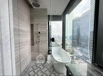 Luxurious bathroom with freestanding tub and stunning city view in modern high-rise apartment.
