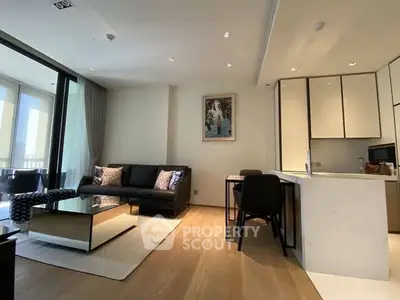 Modern living room with open kitchen, sleek furniture, and large windows for natural light.