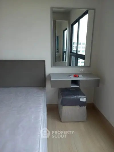 Modern bedroom with minimalist design featuring a sleek mirror and compact desk.