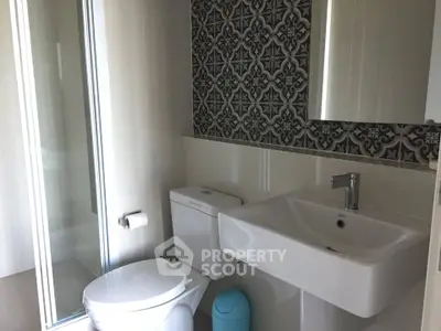 Modern bathroom with stylish tile accent wall and sleek fixtures.