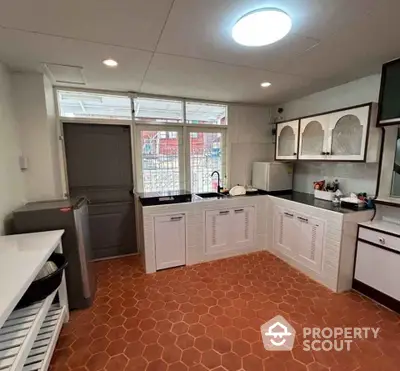 Spacious kitchen with terracotta tiles and ample natural light