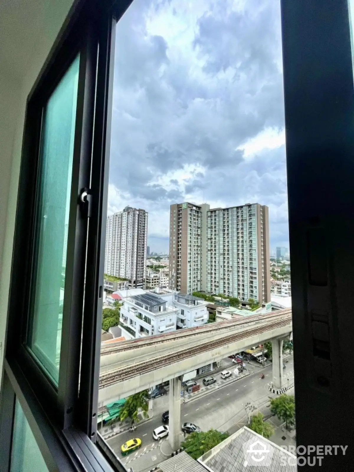 Stunning cityscape view from high-rise apartment window showcasing urban living.