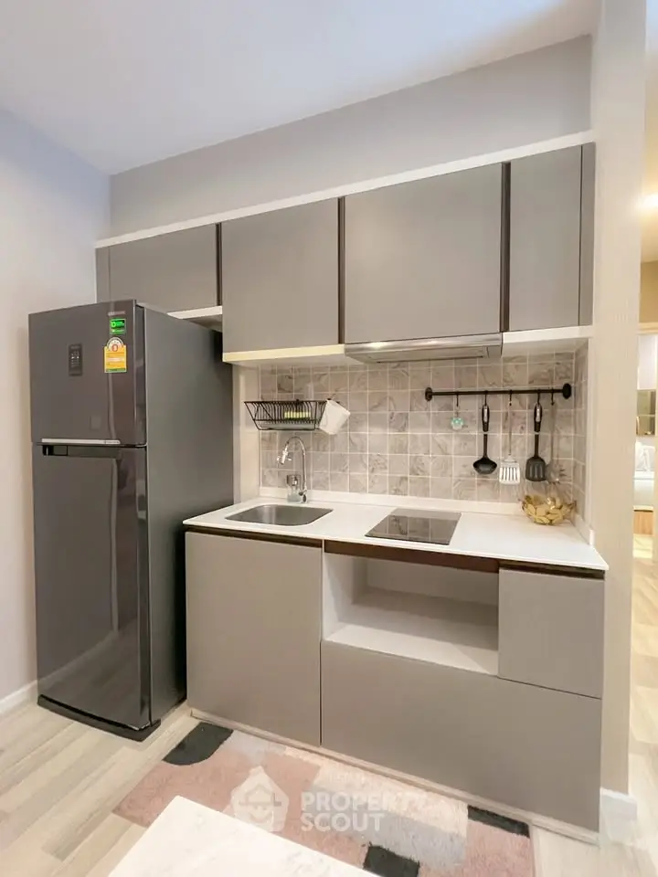 Modern compact kitchen with sleek cabinetry and integrated appliances
