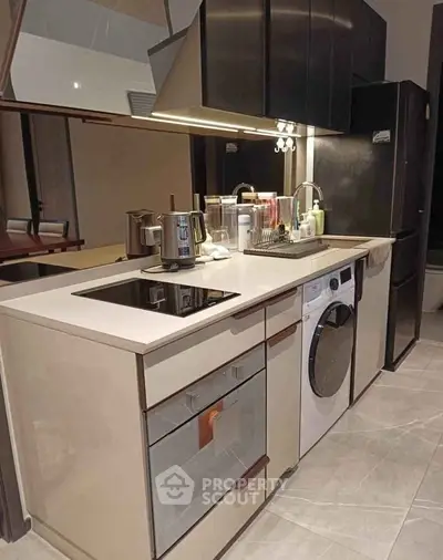 Modern kitchen with sleek appliances and stylish cabinetry, featuring an oven and washing machine.