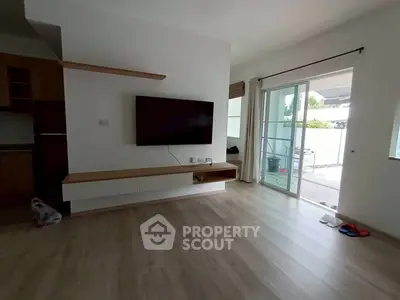 Modern living room with wall-mounted TV and sliding glass doors to balcony