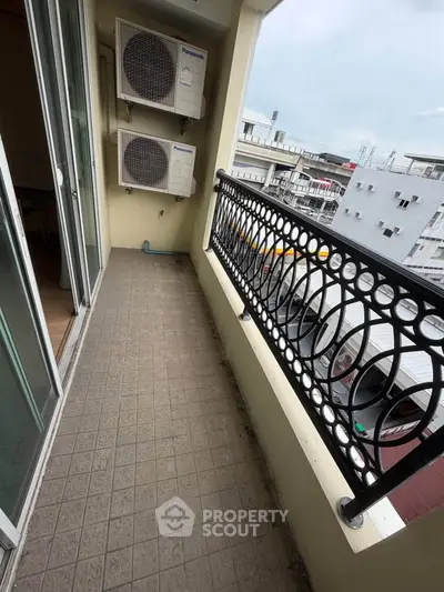 Charming balcony with ornate railing and city view, perfect for relaxation.