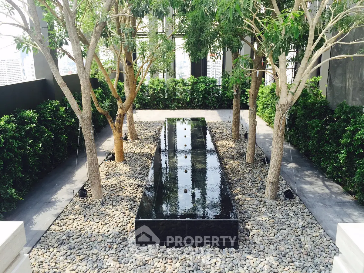 Luxurious rooftop garden with elegant water feature and lush greenery, perfect for relaxation and city views.