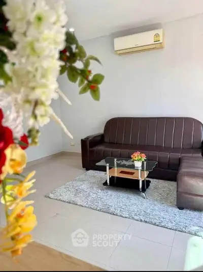 Modern living room with leather sofa and air conditioning, perfect for relaxation.