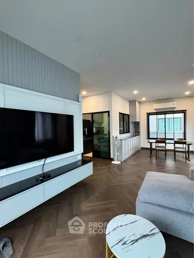 Modern living room with sleek design, large TV, and elegant dining area, perfect for contemporary living.