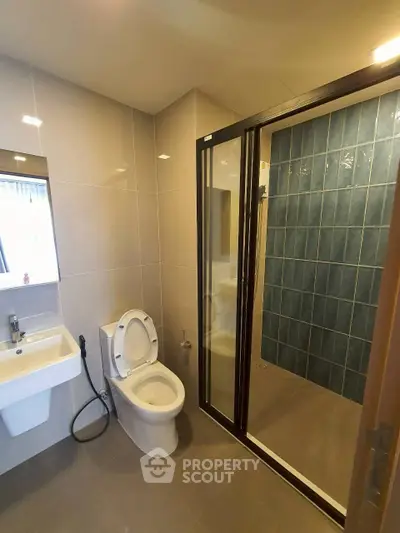 Modern bathroom with sleek design featuring a glass shower enclosure and contemporary fixtures.