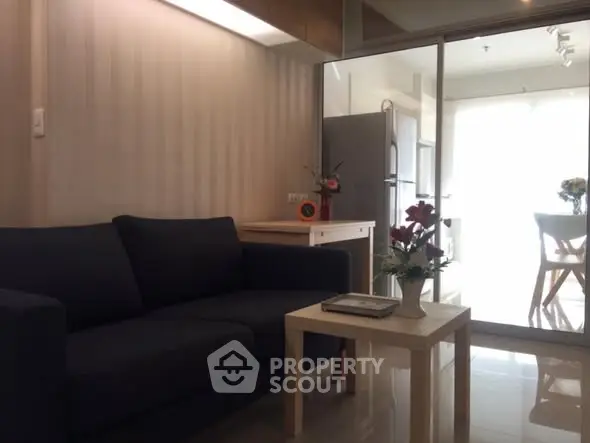 Modern living room with sleek furniture and open kitchen layout, perfect for urban living.