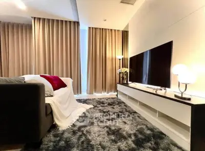 Modern living room with cozy decor, plush rug, and large TV setup for ultimate relaxation.