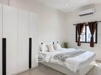 Modern bedroom with sleek white furniture and natural light