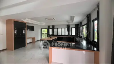 Spacious modern kitchen with sleek black countertops and ample natural light.