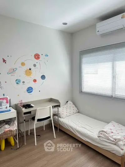 Charming children's bedroom with educational wall art and cozy bed setup.