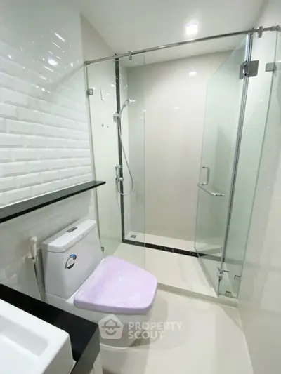Modern bathroom with glass shower and sleek white tiles