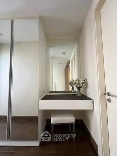 Elegant bedroom corner with mirrored wardrobe and sleek vanity table
