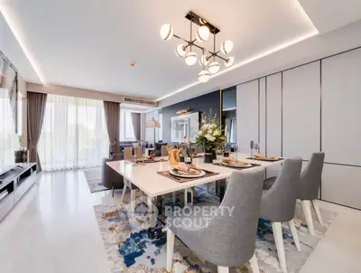Luxurious open-plan living and dining area with elegant decor and modern lighting.