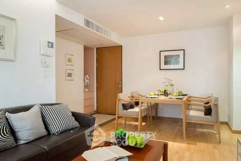 Modern living room with dining area, wooden flooring, and stylish decor