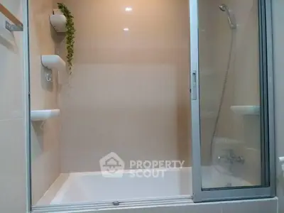 Modern bathroom with glass shower door and built-in bathtub