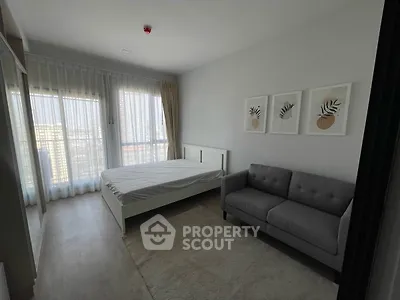 Modern bedroom with large windows and stylish decor in a high-rise apartment.