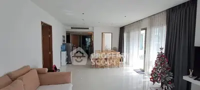 Spacious living room with dining area and Christmas decor, featuring modern furnishings and ample natural light.