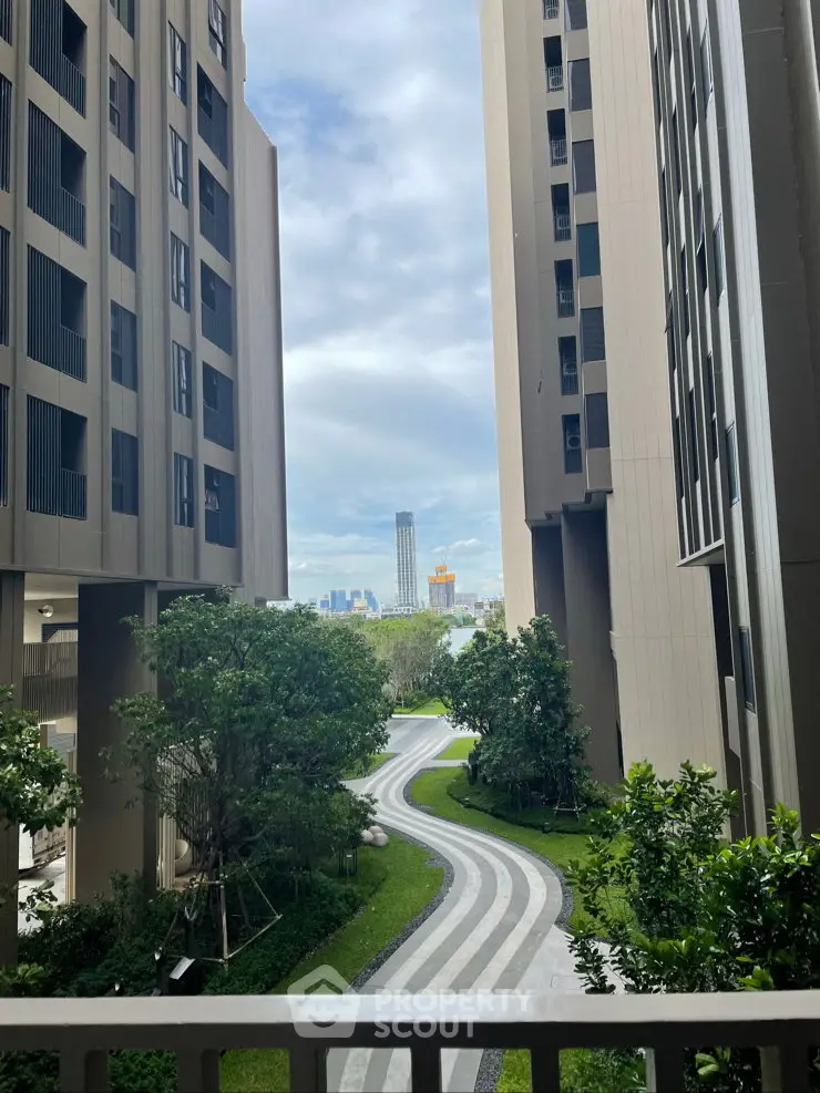 Stunning view from modern high-rise building with lush green garden and cityscape backdrop.