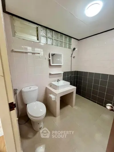 Spacious bathroom with modern fixtures and tiled walls in a real estate property.