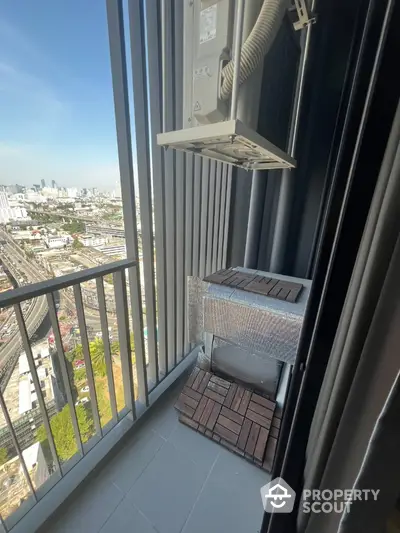 High-rise balcony with city view and air conditioning unit