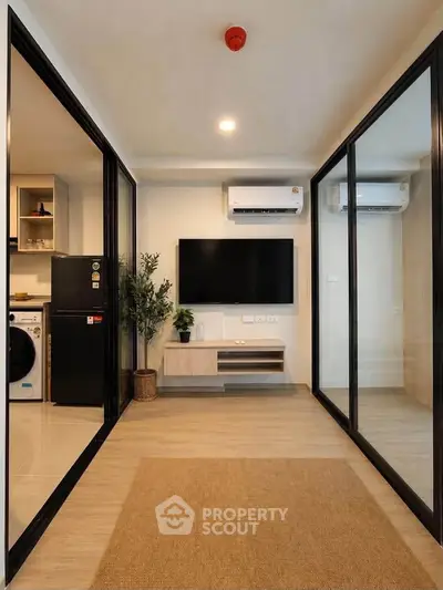 Modern living room with sleek design, featuring air conditioning, TV, and glass partitions for a spacious feel.