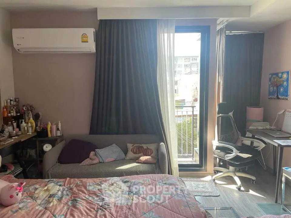 Cozy bedroom with balcony, air conditioning, and study area in modern apartment.