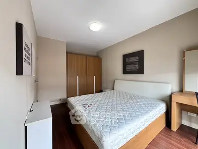 Spacious bedroom with modern furniture and ample natural light, featuring a large bed and stylish decor.