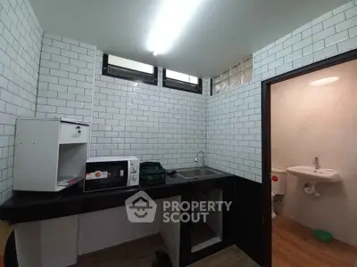 Compact kitchen with white subway tiles and adjacent bathroom