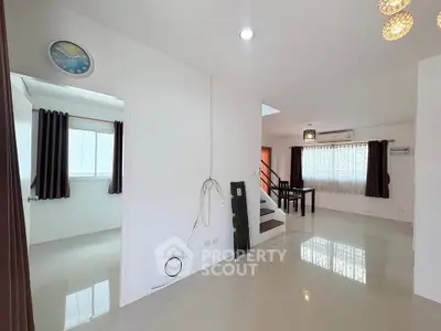 Spacious modern living area with glossy floors and staircase, ideal for family gatherings.
