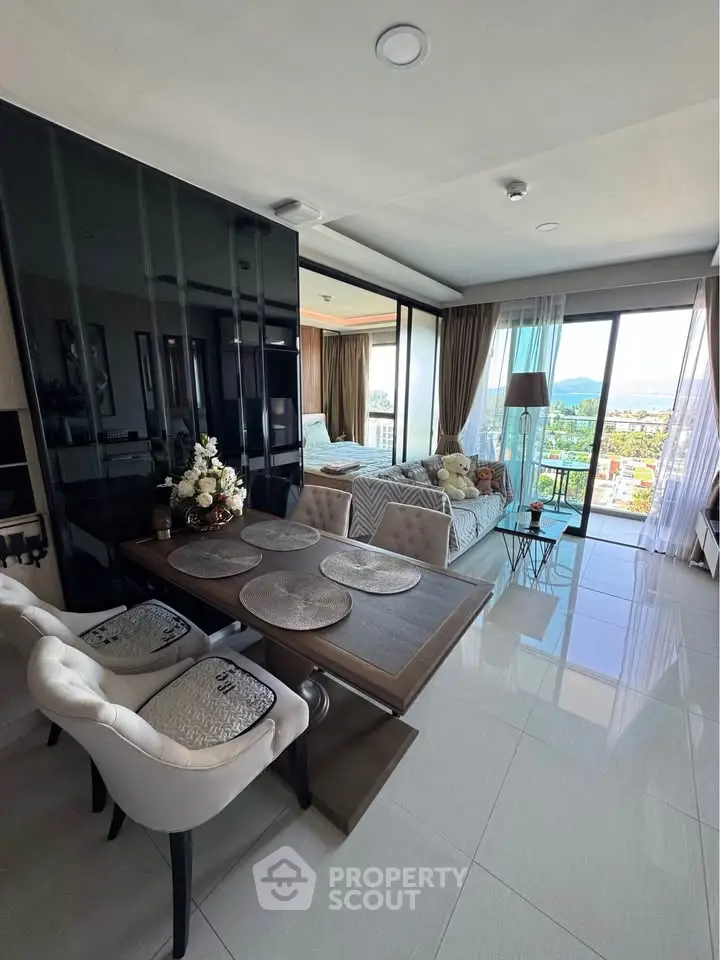 Modern living room with dining area and stunning city view through large windows.