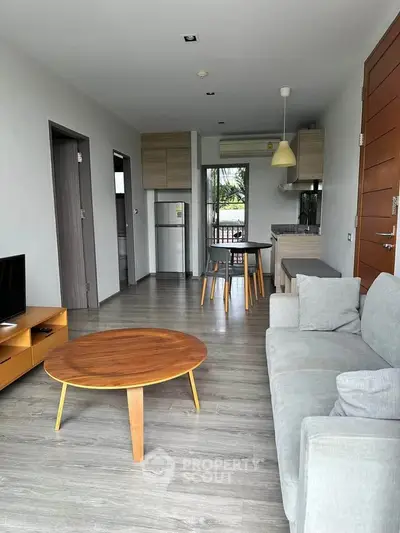 Modern living room with open kitchen and stylish furniture in a bright apartment.