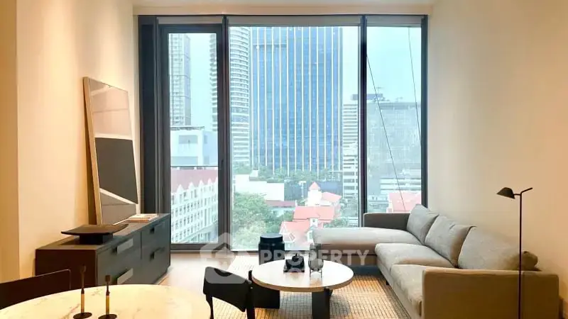 Modern living room with large windows offering stunning city views and stylish furnishings.