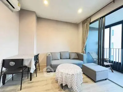 Modern living room with balcony access, stylish furniture, and natural light.