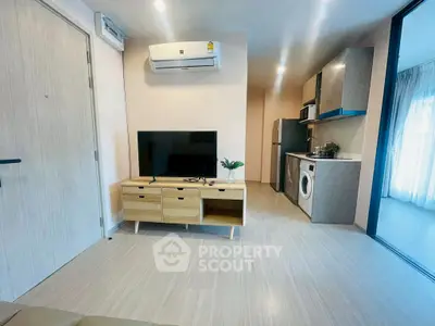 Modern open-plan living room with TV and kitchen appliances