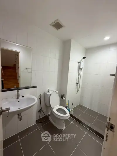 Modern bathroom with sleek fixtures and walk-in shower in contemporary home.
