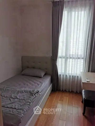 Cozy bedroom with natural light and modern decor, perfect for relaxation.