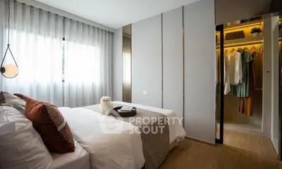 Modern bedroom with cozy decor and walk-in closet, featuring elegant lighting and stylish furnishings.
