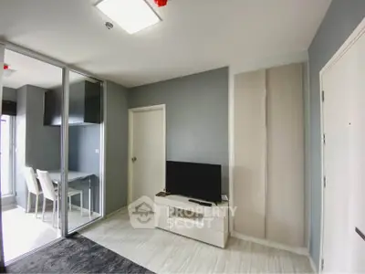 Modern living room with sleek design and glass partition leading to dining area.