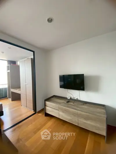 Modern living room with wooden flooring and sleek TV setup